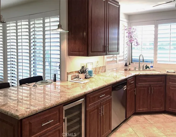 a kitchen with kitchen island granite countertop a sink and a wooden cabinets