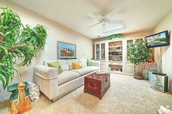 a living room with furniture a chandelier and a large mirror