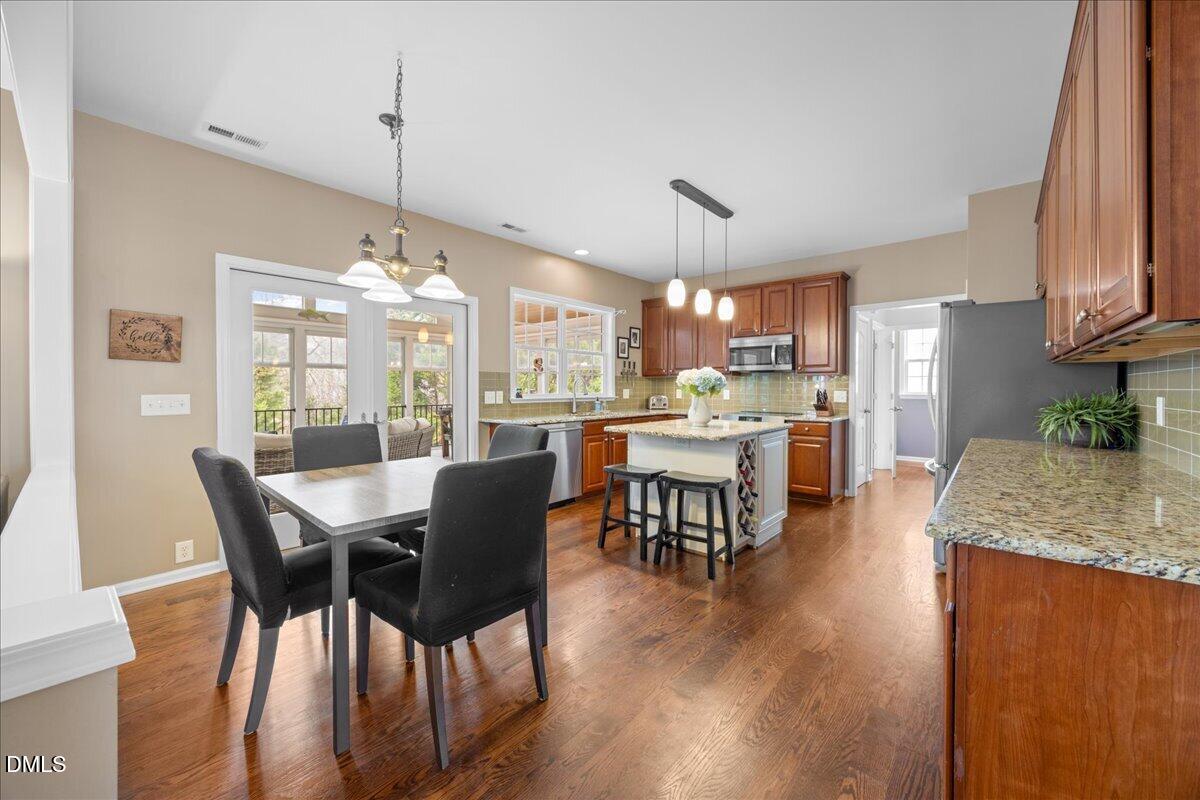 7728 Silver View Lane Raleigh, NC 27613 - Photo 13 of 53 a view of a dining room and livingroom with furniture wooden floor a chandelier