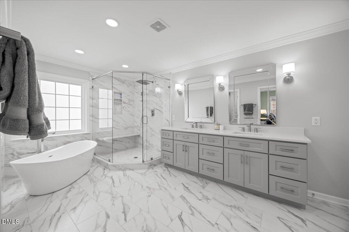 7728 Silver View Lane Raleigh, NC 27613 - Photo 24 of 53 a spacious bathroom with a double vanity sink a large mirror and a bathtub