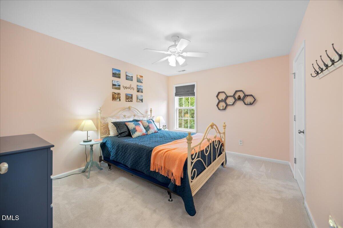 7728 Silver View Lane Raleigh, NC 27613 - Photo 29 of 53 a bedroom with a bed and a chandelier