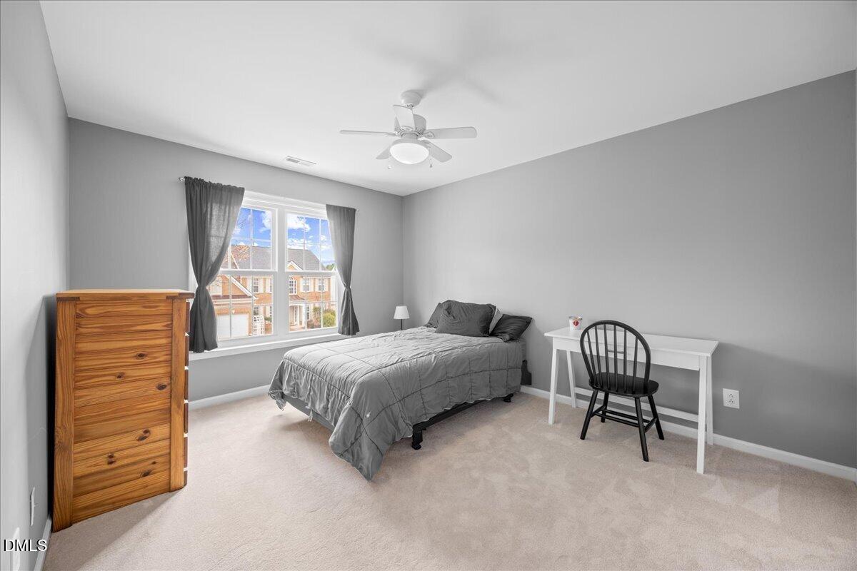 7728 Silver View Lane Raleigh, NC 27613 - Photo 31 of 53 a bedroom with a bed a chandelier and a window