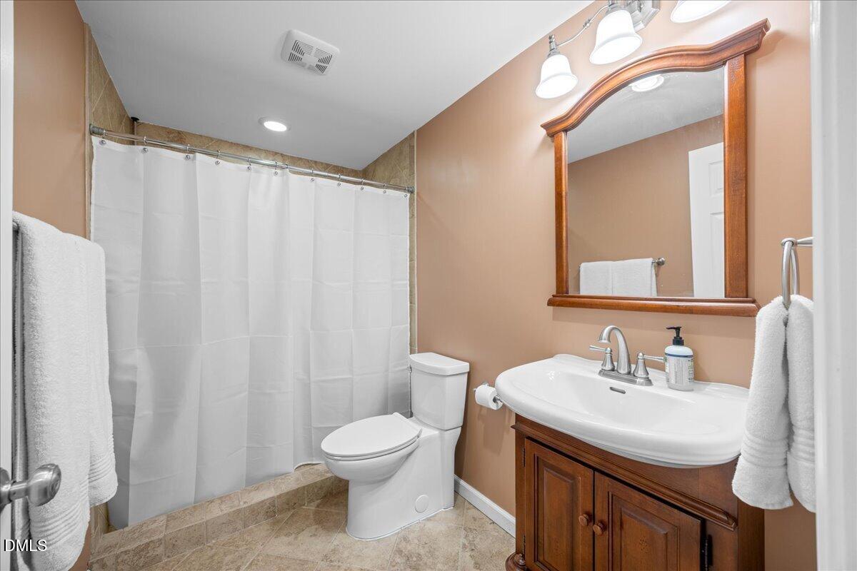 7728 Silver View Lane Raleigh, NC 27613 - Photo 40 of 53 a bathroom with a sink a toilet and a mirror