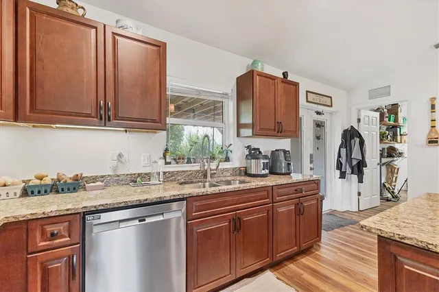 a kitchen with stainless steel appliances granite countertop a sink stove and refrigerator
