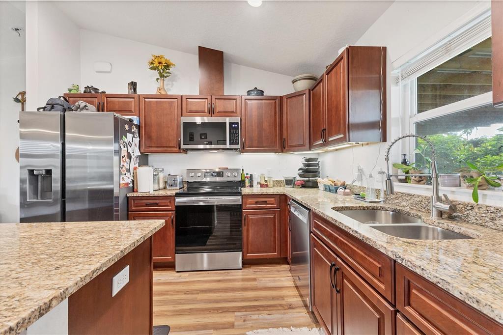 7745 Wauchula Road Myakka City, FL 34251 - Photo 20 of 44 a kitchen with kitchen island granite countertop a sink counter space cabinets and stainless steel appliances