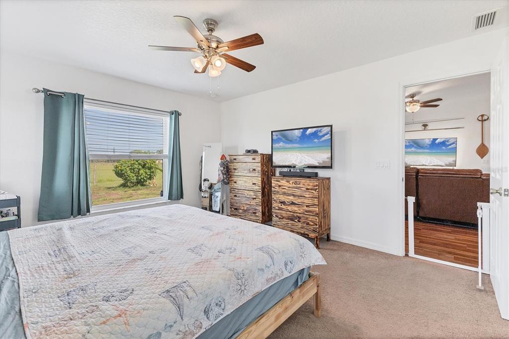 7745 Wauchula Road Myakka City, FL 34251 - Photo 24 of 44 a bedroom with a bed and a chandelier