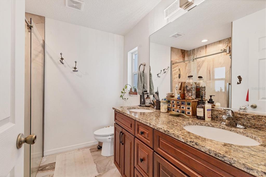 7745 Wauchula Road Myakka City, FL 34251 - Photo 26 of 44 a bathroom with a granite countertop sink a mirror and a toilet