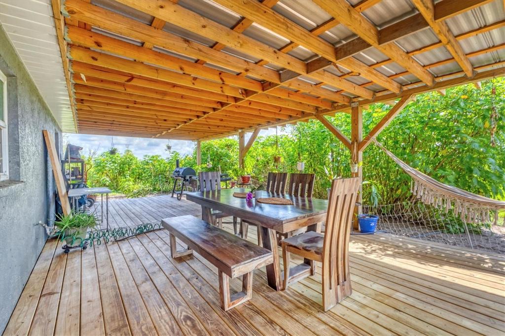 7745 Wauchula Road Myakka City, FL 34251 - Photo 31 of 44 a view of a patio with table and chairs and wooden floor
