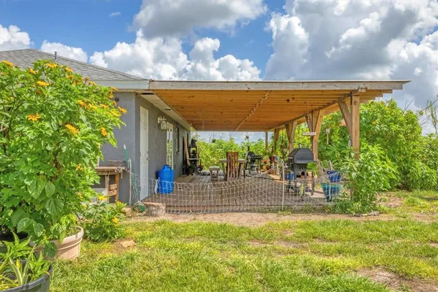 a view of a porch with a table and chairs under an umbrella