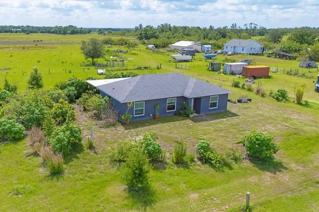 an aerial view of a house with a garden and lake view