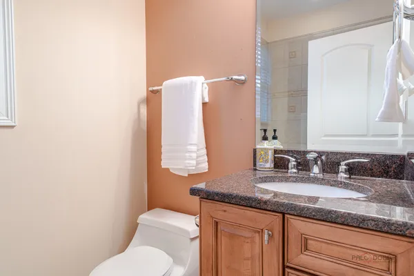 a kitchen with stainless steel appliances granite countertop a dining table chairs and chandelier