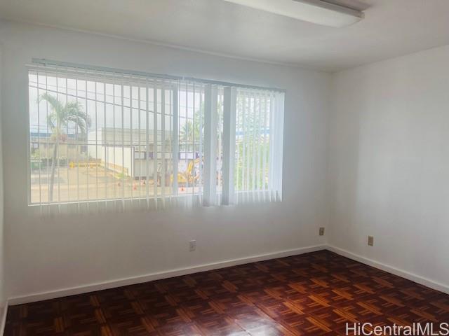 1728 Dillingham Boulevard, Unit B Honolulu, HI 96819 - Photo 11 of 15 an empty room with wooden floor and windows
