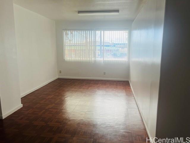 1728 Dillingham Boulevard, Unit B Honolulu, HI 96819 - Photo 9 of 15 an empty room with wooden floor and windows