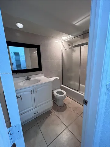 a bathroom with a toilet a sink a mirror and vanity