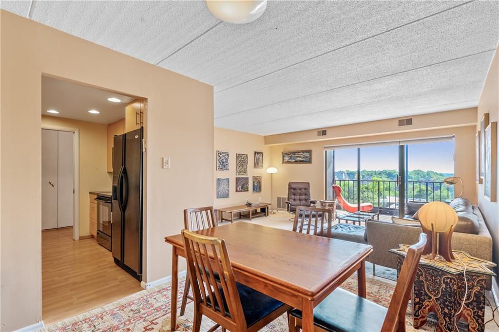 5600 Munhall Road, Unit 816 Pittsburgh, PA 15217 - Photo 7 of 20 a view of a dining room with furniture large windows and wooden floor