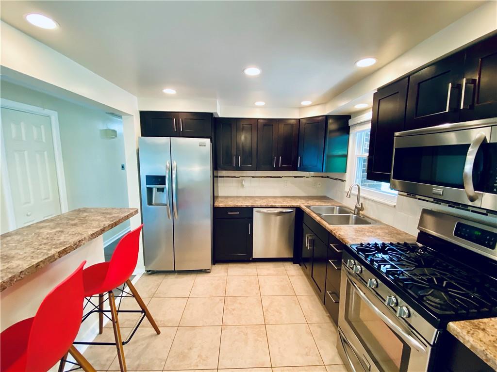 27 Flora Road Pittsburgh, PA 15227 - Photo 8 of 19 a kitchen with stainless steel appliances granite countertop a stove a sink dishwasher a refrigerator and a microwave