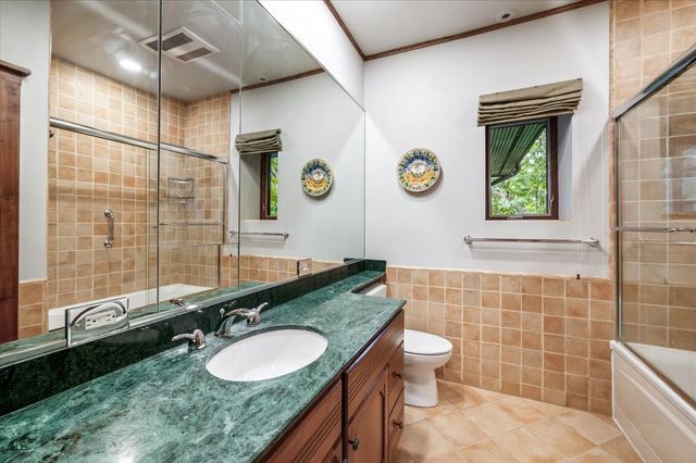 a bathroom with a granite countertop sink toilet and a shower