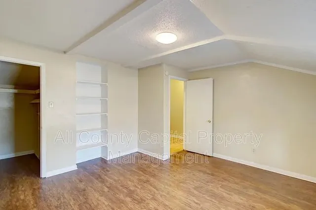 an empty room with closet and wooden floor
