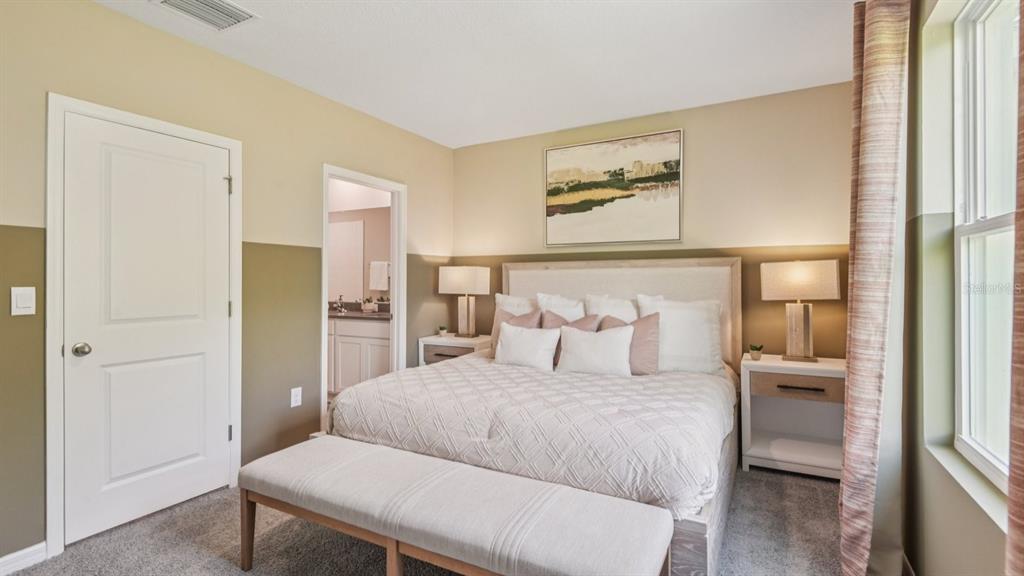 32471 Welling Blade Loop Wesley Chapel, FL 33545 - Photo 21 of 42 a bedroom with a large bed and painting on the wall