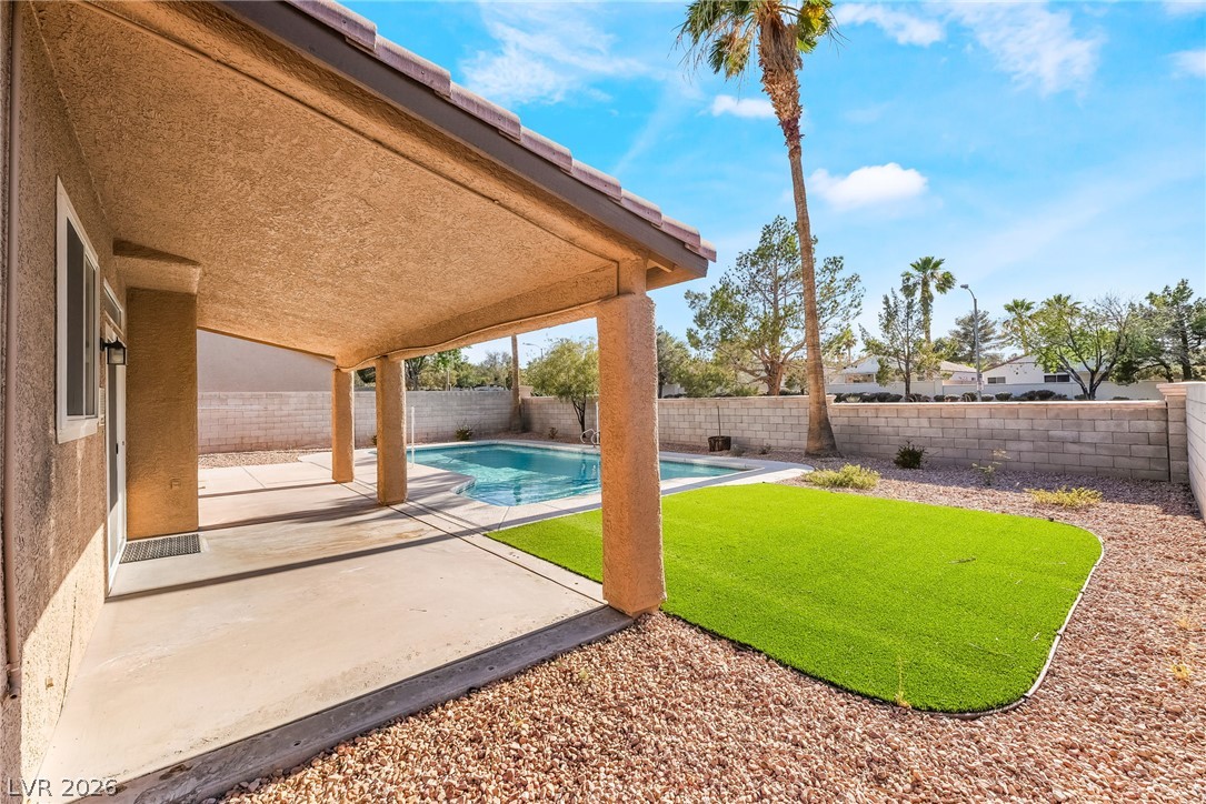 261 Timber Hollow Street Henderson, NV 89012 - Photo 46 of 51 A private backyard oasis features a shimmering pool and covered patio for optimal outdoor enjoyment.