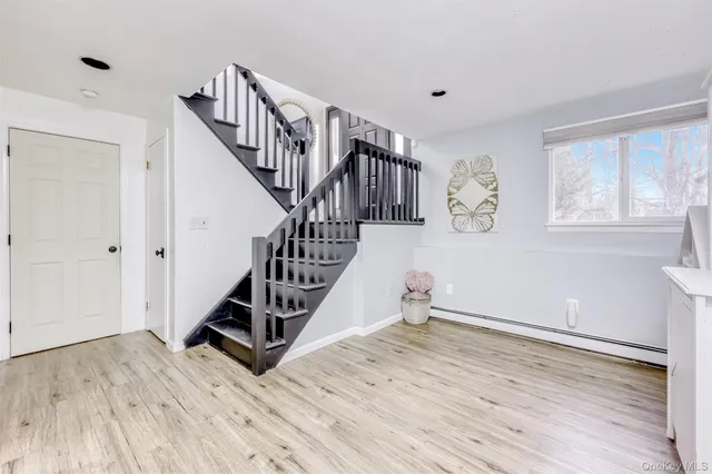 a view of entryway and hall with wooden floor