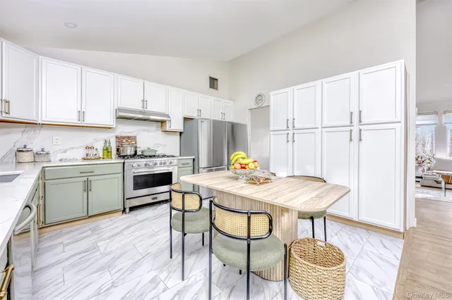 a kitchen with a table chairs sink and cabinets