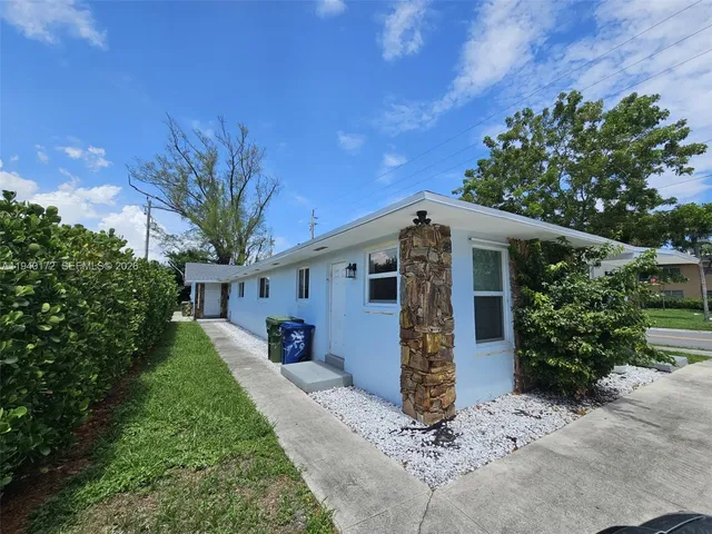 a front view of house with yard and trees
