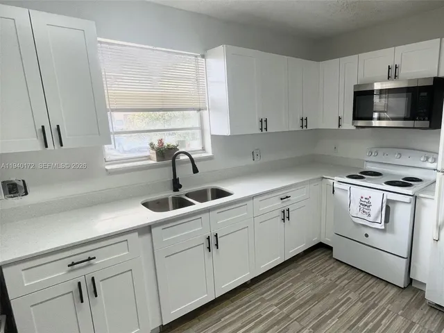 a kitchen with white cabinets and white appliances