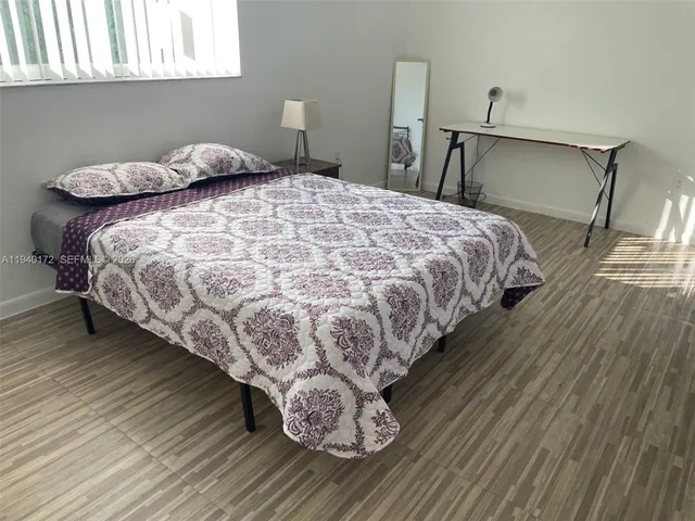 a large bed sitting in a bedroom next to a window