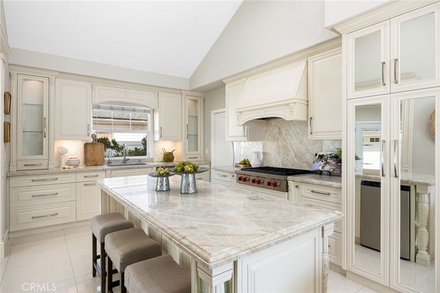 a kitchen with kitchen island granite countertop a stove and a sink