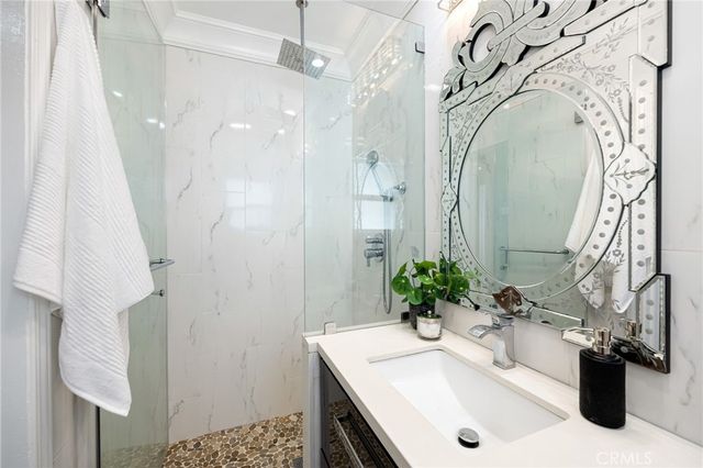 a bathroom with a sink a potted plant and a shower