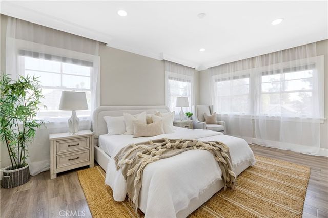 a bedroom with a large bed and a potted plant