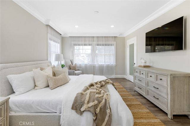 a bedroom with a large bed and a flat screen tv