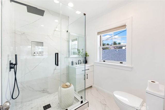 a bathroom with a granite countertop sink a toilet and shower