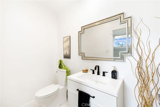 a bathroom with a sink vanity mirror and toilet