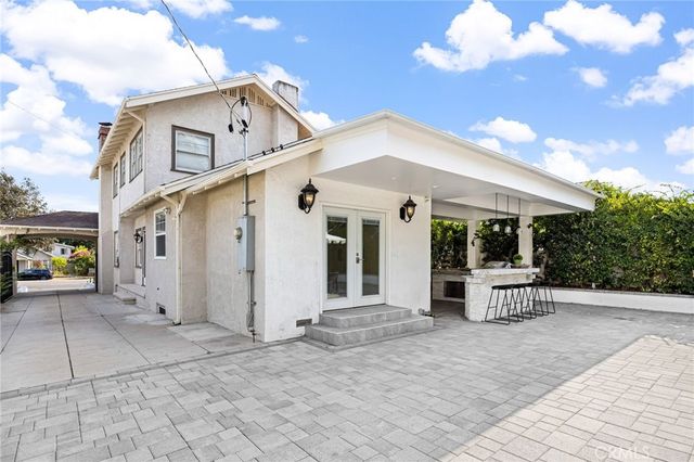 a view of a white house with a bench in front of it