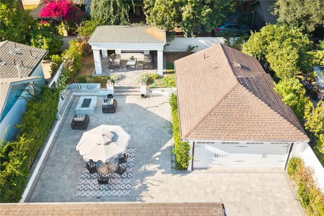 a front view of a house with a garden and fountain