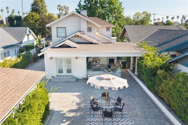 a view of a white house with a yard table and chairs