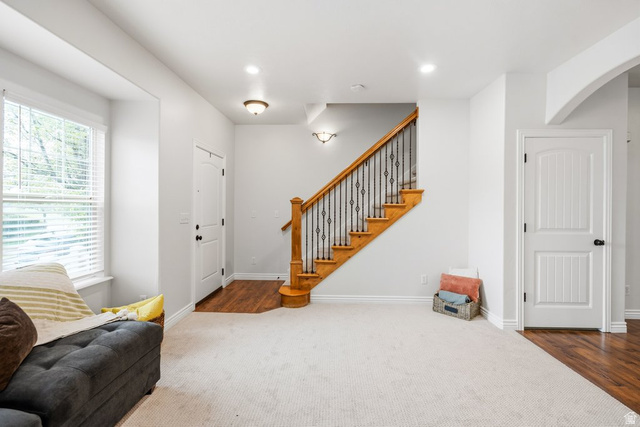 2029 West Crescent Row Mapleton, UT 84664 - Photo 5 of 35 Staircase with wood treads and wrought iron balusters, white paneled doors, recessed lighting, and wood-finish flooring at entry points
