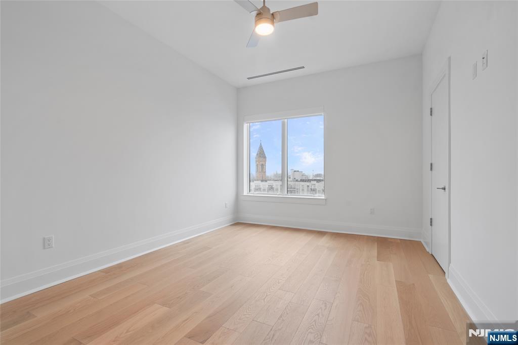 620 Bloomfield Avenue, Unit PHB Bloomfield, NJ 07003 - Photo 12 of 36 an empty room with wooden floor and windows