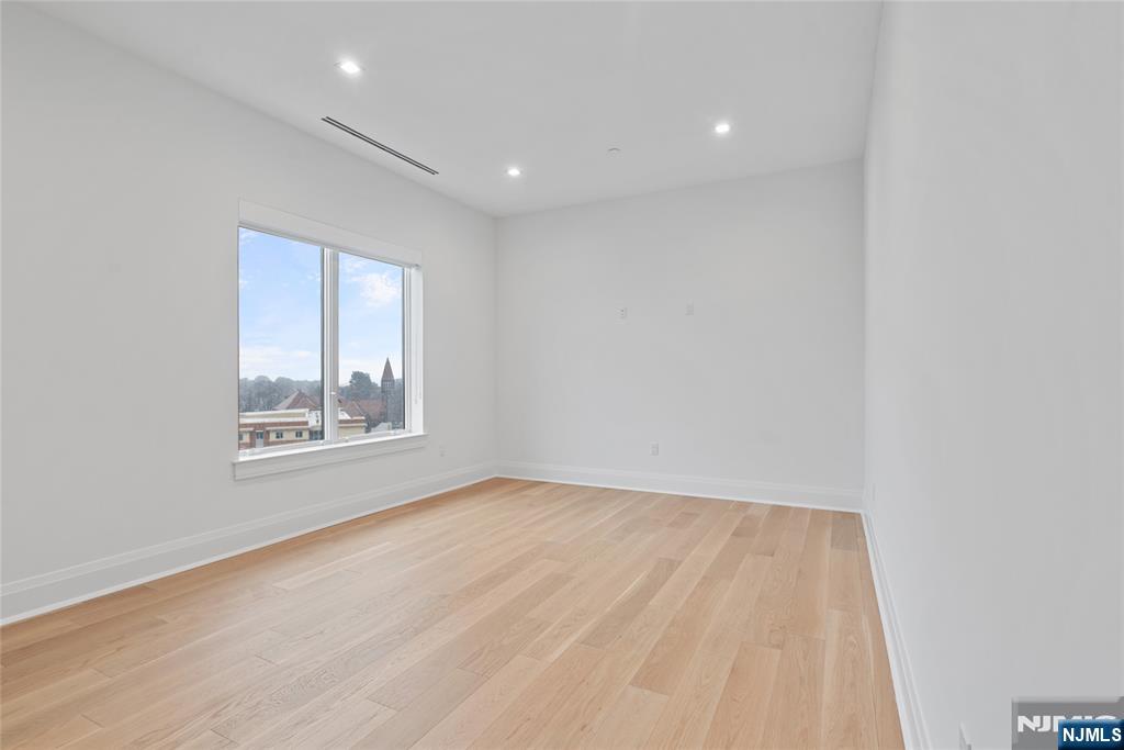 620 Bloomfield Avenue, Unit PHB Bloomfield, NJ 07003 - Photo 10 of 36 a view of an empty room with wooden floor and a window