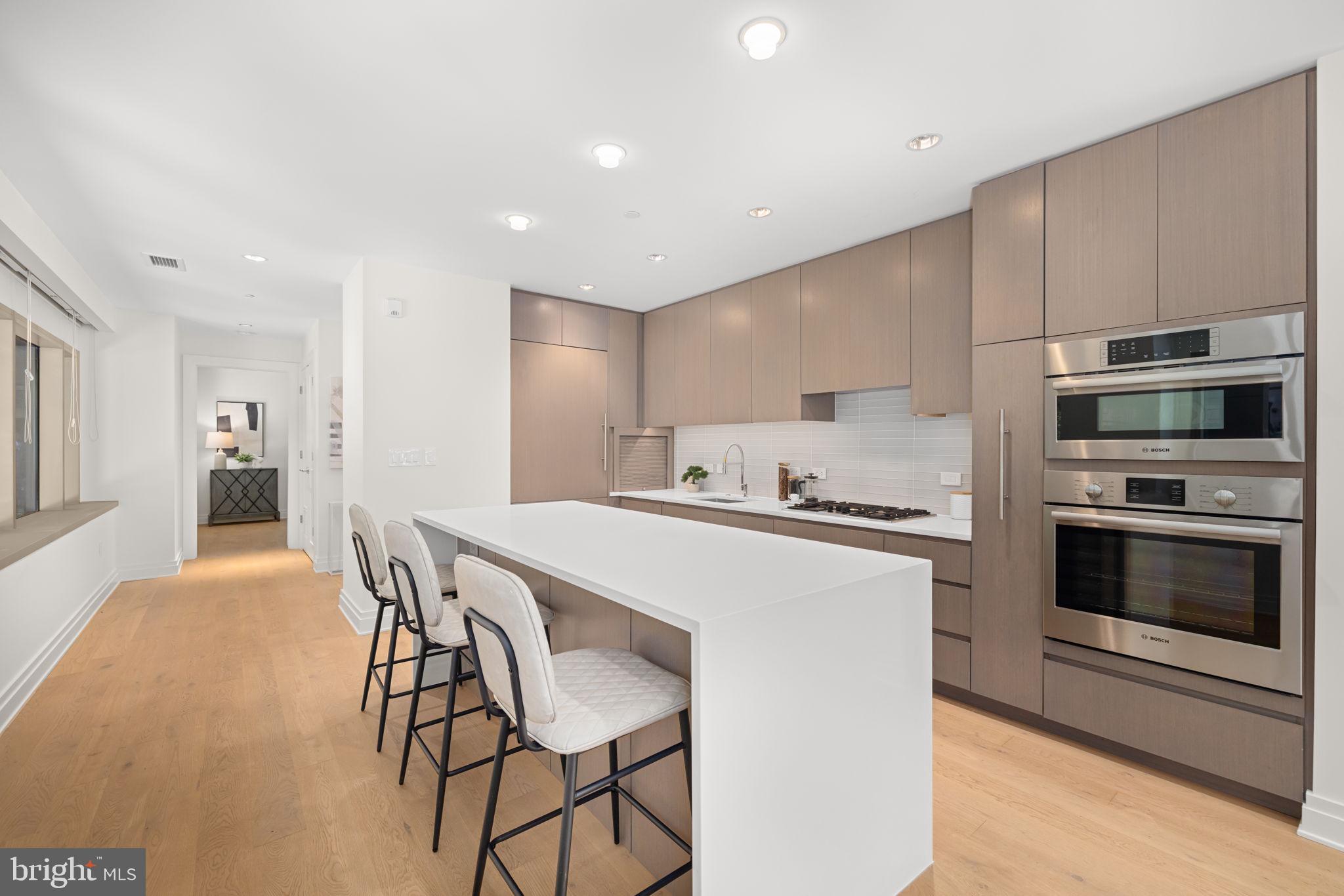 2501 M Street Northwest, Unit T04 Washington, DC 20037 - Photo 6 of 24 a kitchen with stainless steel appliances a stove a microwave a sink and white cabinets