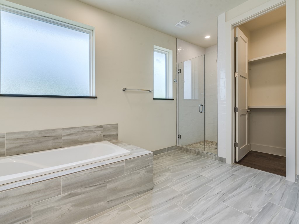 6412 Carson Ridge, Unit B Austin, TX 78741 - Photo 11 of 29 a bathroom with a bathtub and a shower