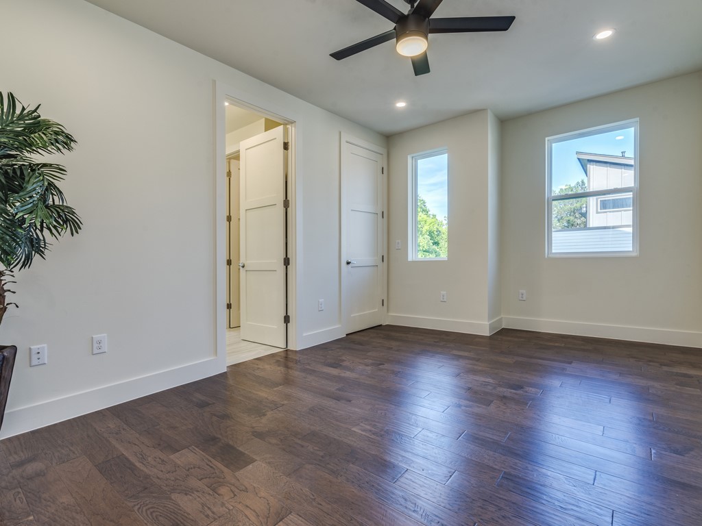 6412 Carson Ridge, Unit B Austin, TX 78741 - Photo 8 of 29 an empty room with wooden floor and windows
