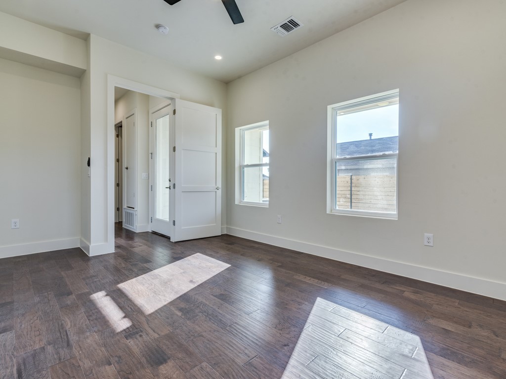 6412 Carson Ridge, Unit B Austin, TX 78741 - Photo 9 of 29 an empty room with wooden floor and windows