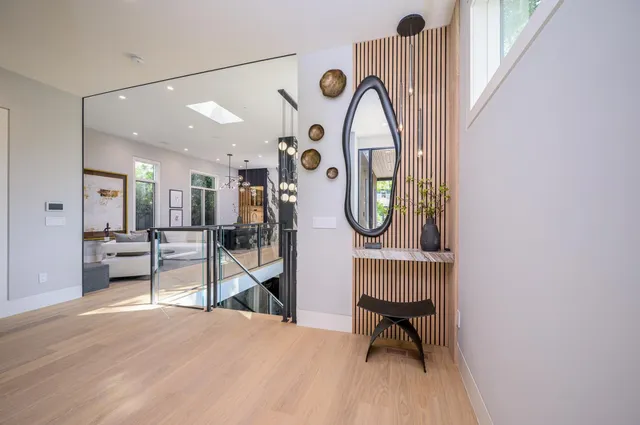 a view of a hallway with wooden floor table and chairs
