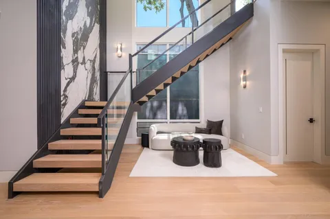 a living room with stainless steel appliances granite countertop furniture and a large window