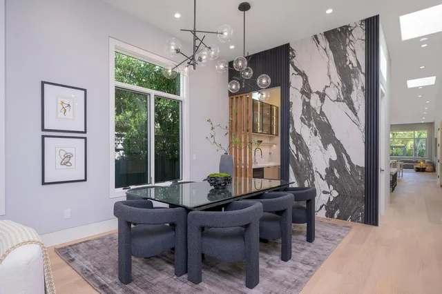 a living room with furniture a potted plant and a large mirror