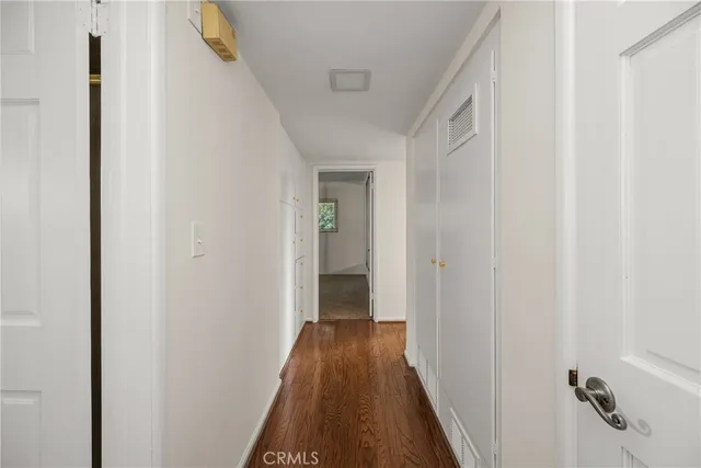 a view of a hallway with wooden floor and closet