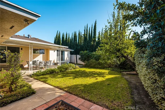 a view of a house with backyard and sitting area